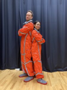 Två astronauter i orangea dräkt.