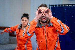 En astroanut använder händerna som kikare och en annan står bakom.