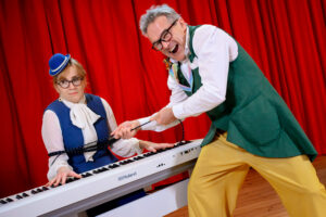 man och kvinna spexar vid ett piano.